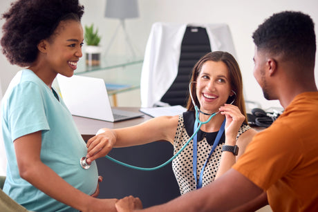 A nurse Midwife listens to a pregnant woman's stomach