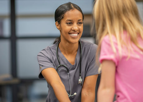 A school nurse talks with a young student in the nurses office