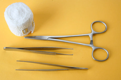 Dry Dressings with nursing scissors and tweezers on a yellow background