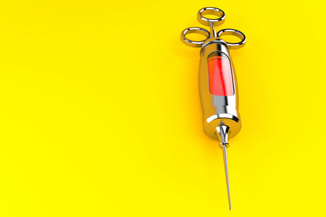 Large old-school syringe on orange background