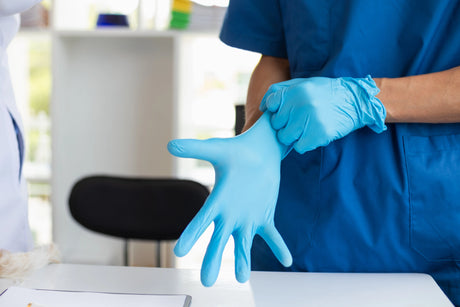 Nurse safely putting on sterile gloves