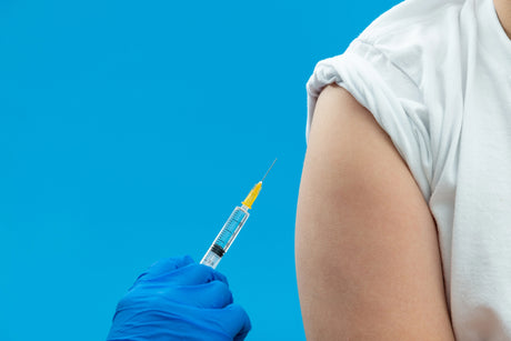 Nurse with blue latex gloves preps an upper arm for a subcutaneous injection