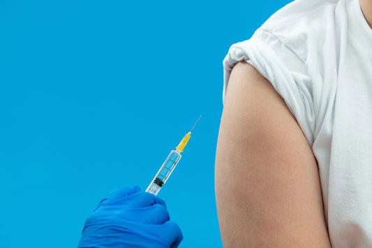 Nurse with blue latex gloves preps an upper arm for a subcutaneous injection
