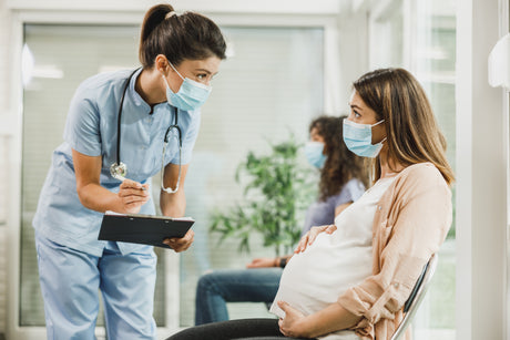 Pretty young woman female nurse attends to a pretty young female preterm pregnant woman