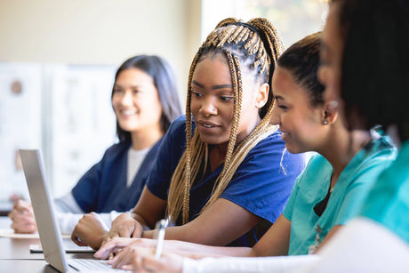 Nursing students looking at a computer screen and learning how to pass nursing school