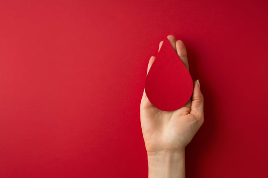 Red drop of blood on a nurses hand with a red background
