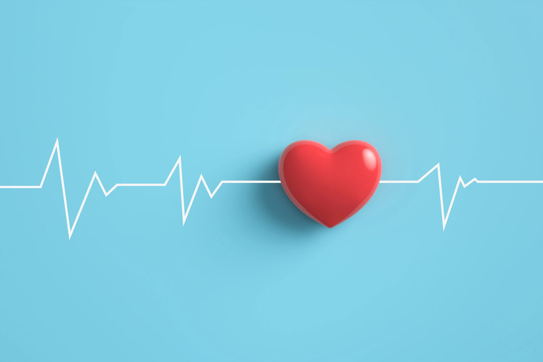Red heart with ekg wave through it on blue background