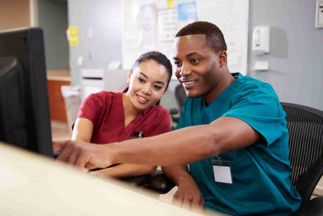 Male and Female Nurse Working At Nurse's Station