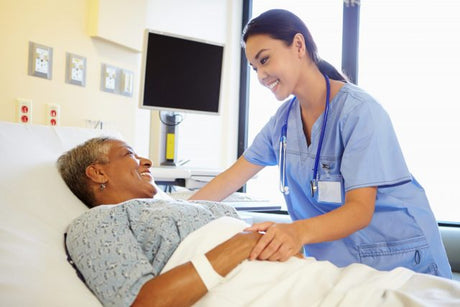 A young female Asian nurse reassures a black senior woman in a hospital bed what are nursing interventions