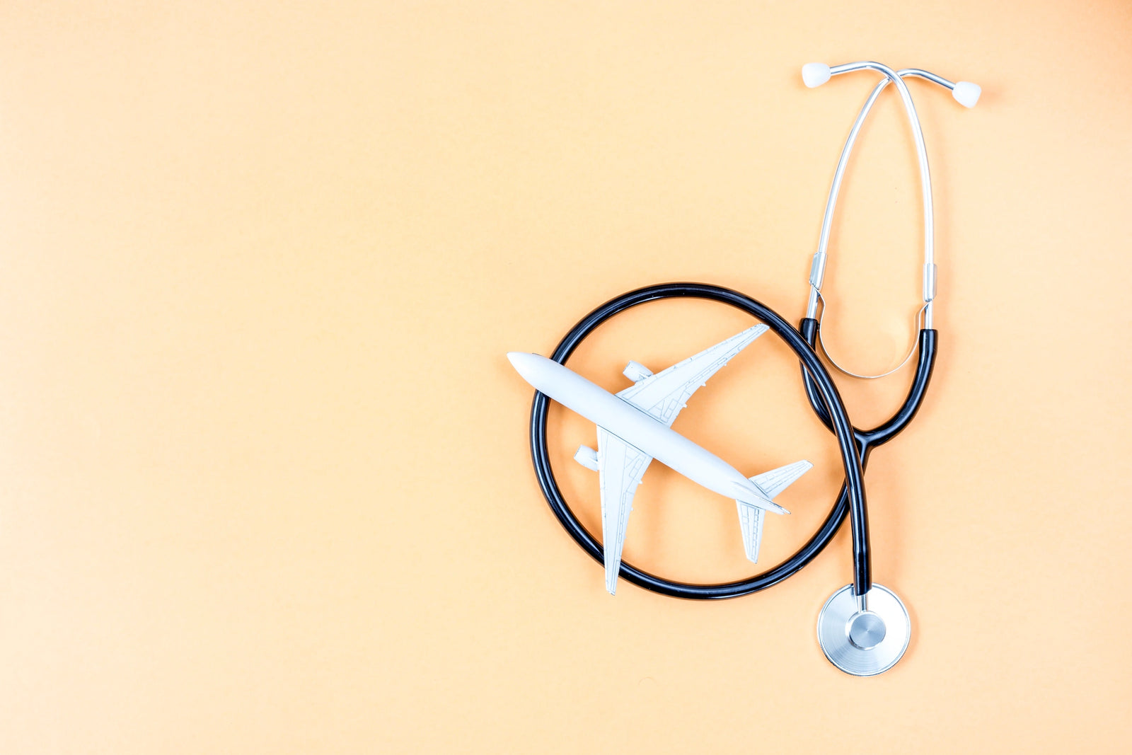 Stethoscope and airplane on an orange background