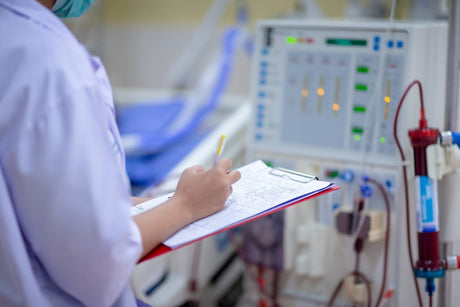 Nurse with clipboard next to dialysis machine - nursing interventions for acute renal failure title card