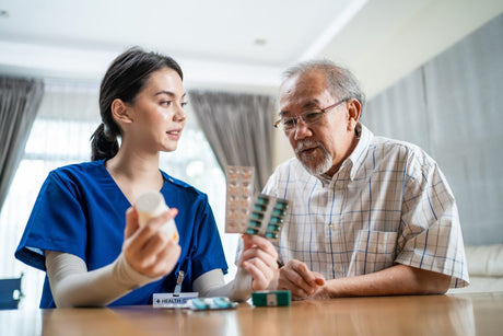 Young female nurse going over different antibiotics with elder Asian patient, including macrolide antibiotics