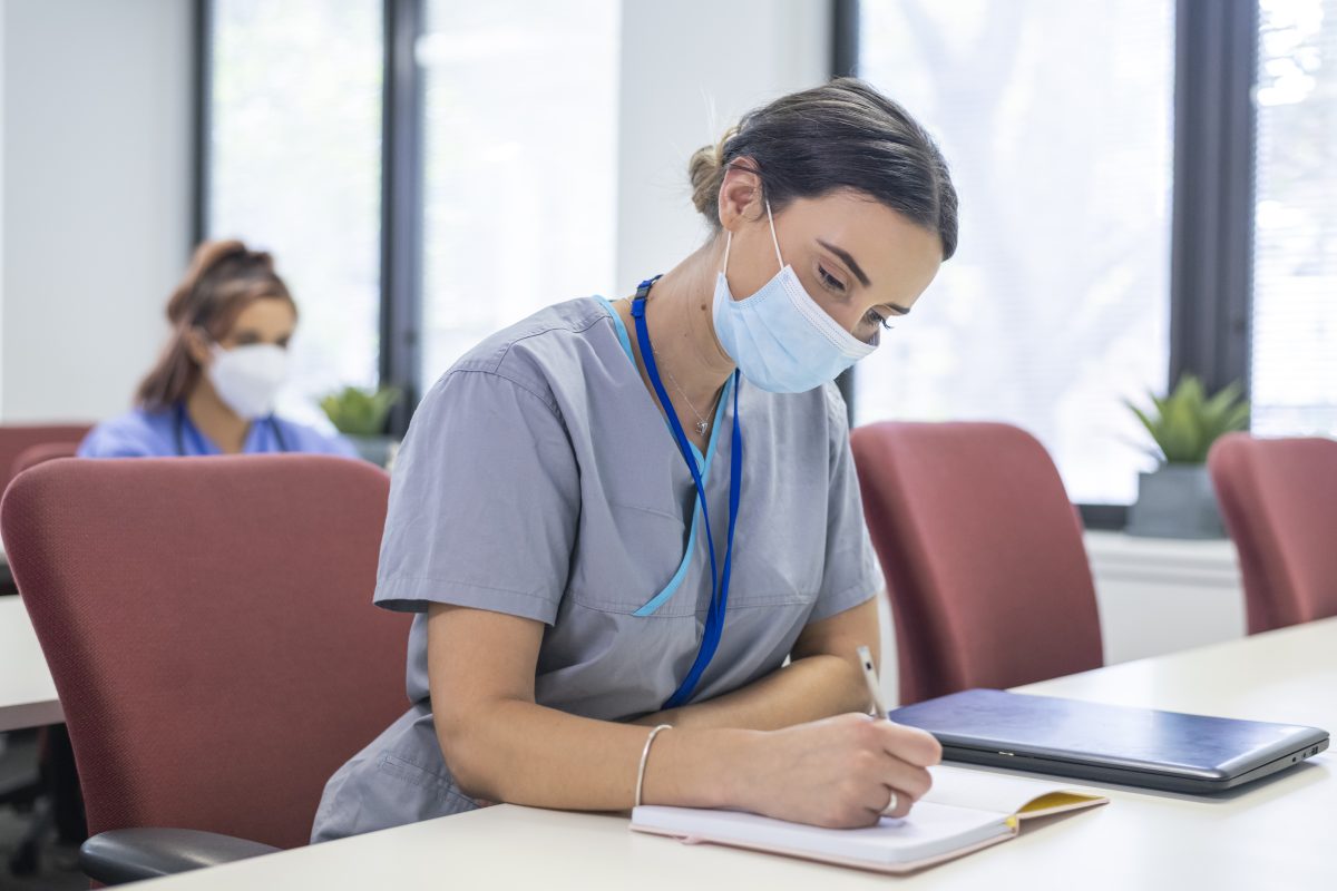 Nurse wearing a PPE mask is taking exam for ccrn nursing certification