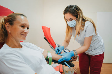 Young female nurse in a mask drawing blood from a female patient pernicious anemia title card