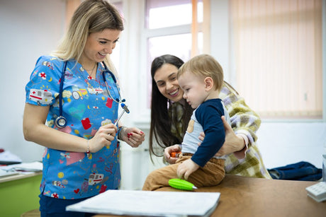 Pediatric nurse checking baby patient with reflex hammer
