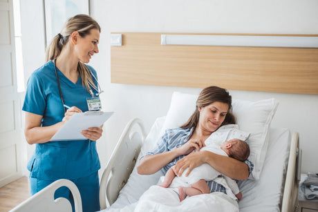 Newborn baby with his mother at hospital. Nurse taking personal data from mother and talking to her. Mother holding newborn baby.