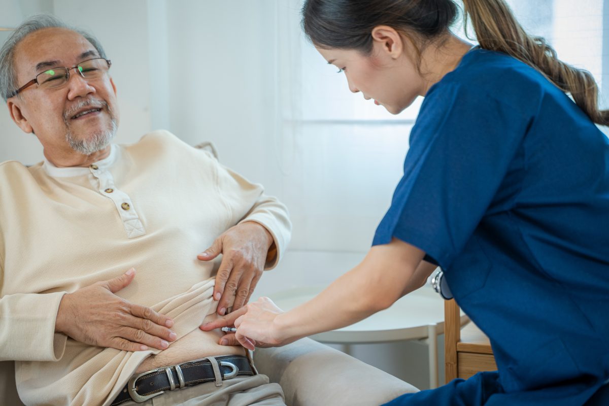 Asian nurse injects a diabetic injection on a patient's stomach,Medical treatment.