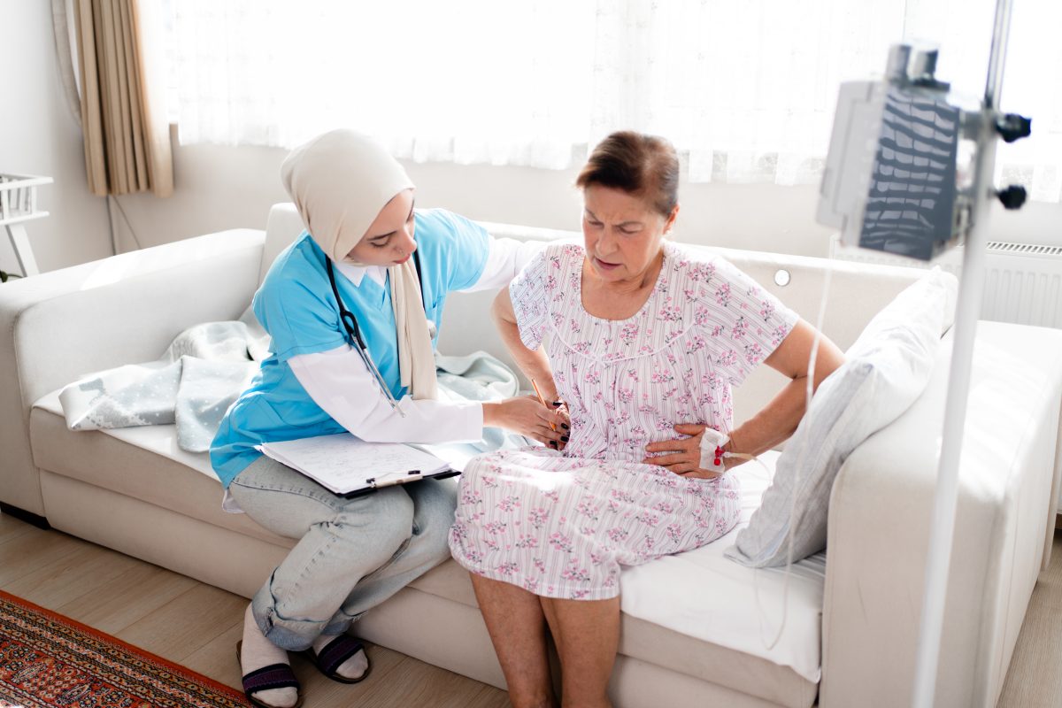 Abdominal pain patient woman having medical exam with Muslim nurse on illness from stomach cancer, irritable bowel syndrome, pelvic discomfort, Indigestion, Diarrhea, GERD (gastro-esophageal reflux disease)