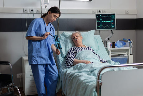 Nurse with patient going over ARDS stages with an elder senior woman patient in bed