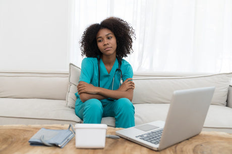 Stressed young female doctor while working in hospital. Tired female nurse in office at hospital