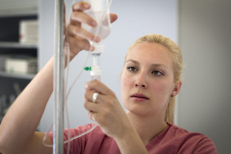 Nurse holding iv bag - title card for infiltration vs extravasation