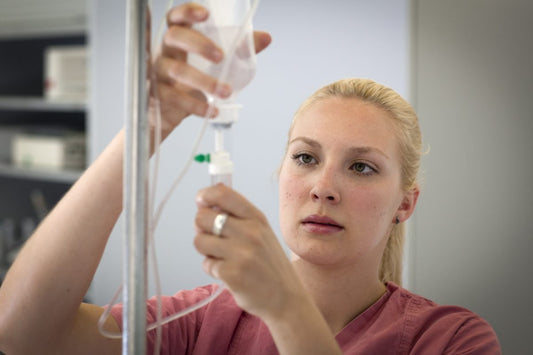 Nurse holding iv bag - title card for infiltration vs extravasation