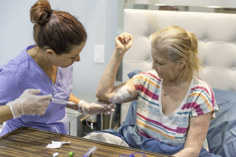A woman female nurse administers nutrition to a senior woman. Total Parenteral Nutrition (TPN)?