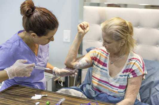 A woman female nurse administers nutrition to a senior woman. Total Parenteral Nutrition (TPN)?
