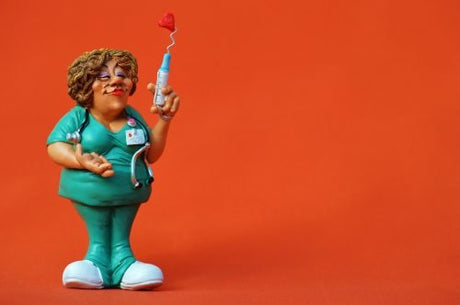 Sculpture caricature of a nurse with a love needle (A needle is made up of the hub, shaft, and bevel. The hub fits onto the tip of the syringe.)