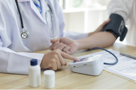 Nurse practitioner checks a woman's bloodpressure with an electronic automatic PB cuff.
